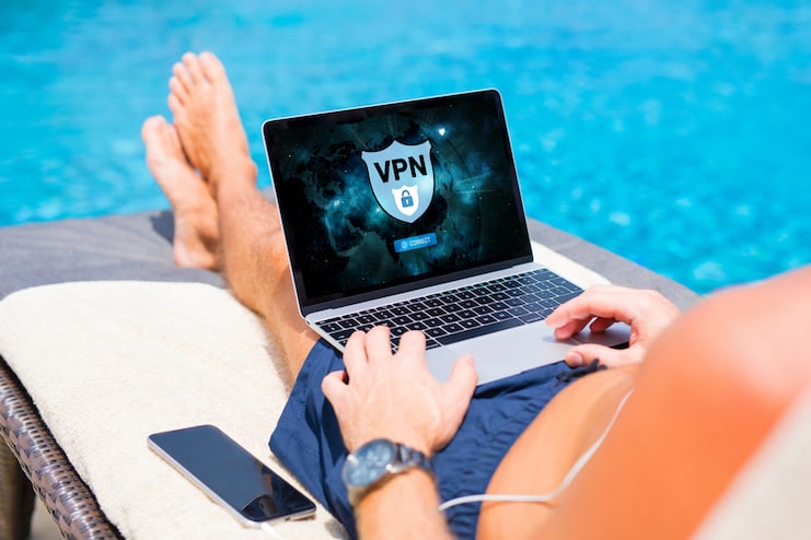 Man using VPN on laptop by the pool